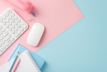Elegant top view of modern office desk with keyboard, mouse, and stationary on dual-tone pastel background in pink and blue shades