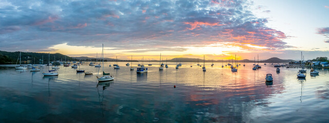 Aerial sunrise waterscape with boats, clouds and reflections