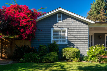 Classic American suburban house with a bright and vibrant flower garden in the front yard