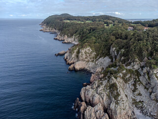Fototapeta premium Idyllic remote coast is dotted with an abundance of lush evergreen trees in Varberg, Sweden