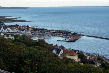 Picturesque coastal town is featured in this image, with a bay of boats docked at the shoreline
