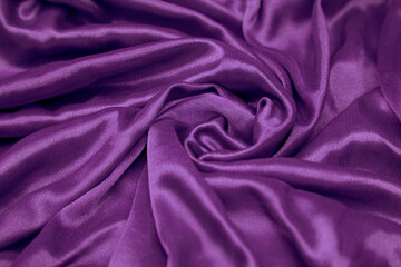 a purple fabric draped to the side of a bed with black sheets