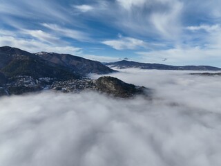 fog rolls around mountains as clouds move overhead in this view