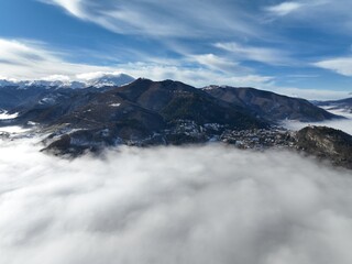 Obraz premium a snow covered mountain landscape and clouds above it with mountains