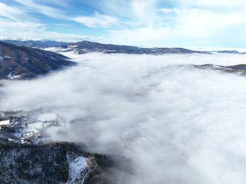 clouds are rolling over the mountain in a large amount of snow