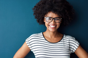 Black woman, portrait and smile with glasses for optometry or vision and on blue background. Girl,...