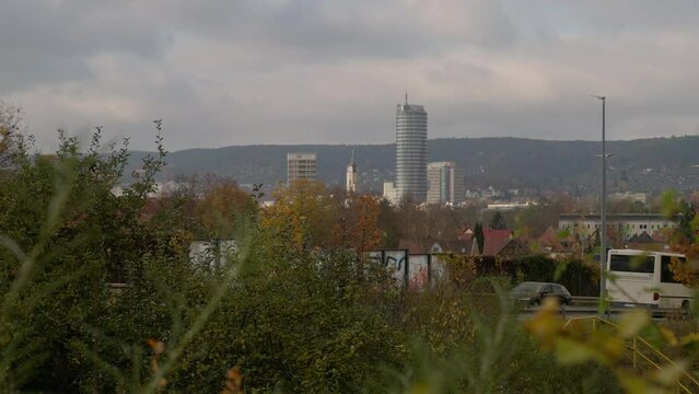 Vehicles driving on the highway road with JenTower in the background at sunset in Jena City, Germany