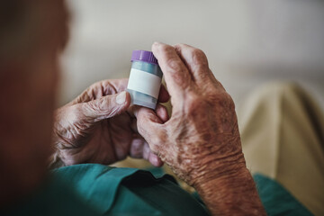 Senior person, hands and reading with pills for illness, medication or sickness symptoms at old age...
