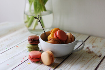 multi-colored macarons in a cup on the table 