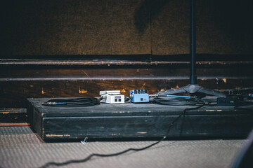 a black box sitting on the ground near a guitar amplifier