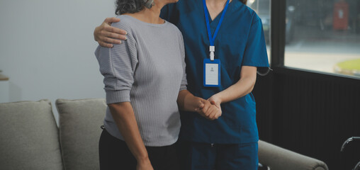 Female caregiver doing regular check-up of senior woman in her home.