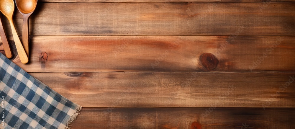 Poster a copy space image with wooden kitchen tools and a napkin placed on a wooden background
