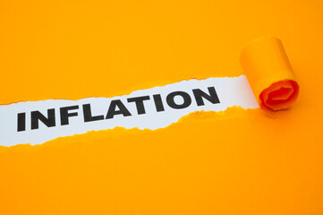 White surface, with the word Inflation in black, underneath torn and rolled yellow cardboard.
