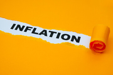 White surface, with the word Inflation in black, underneath torn and rolled yellow cardboard.
