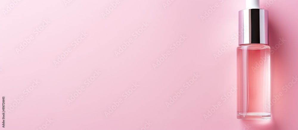 Poster Top down view of a cosmetic serum placed on a pink background creating an ideal copy space image for text placement