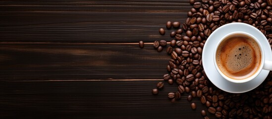 A top view of a cup of espresso coffee placed on a wooden table surrounded by coffee beans and ground coffee Ample space available for adding images or text