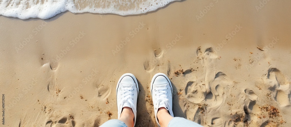 Poster a summer themed selfie of fashionable white sneakers on a sandy beach captured from a top down persp