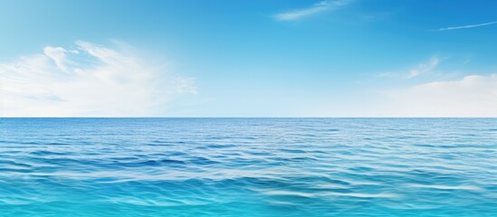 Fototapeta premium A serene clear sea creates a wide horizontal copy space image perfect for print or web banners with a white room for text The panoramic view offers a calming and relaxing background surface water tex