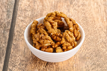 Cracked unshelled walnut in the bowl