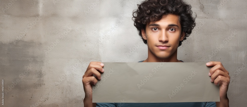 Poster a young man of hispanic descent holding a sign with empty space for images or text. with copy space 