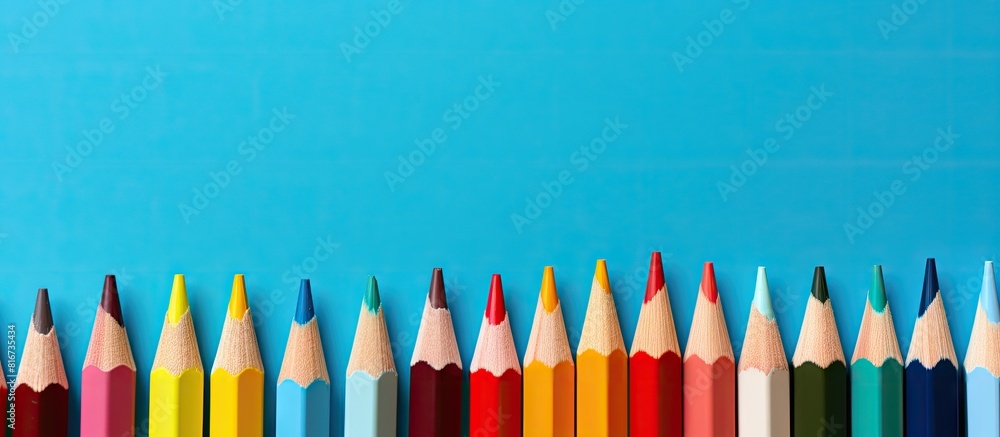 Aufkleber Top view of color pencils on a blue background with plenty of copy space image