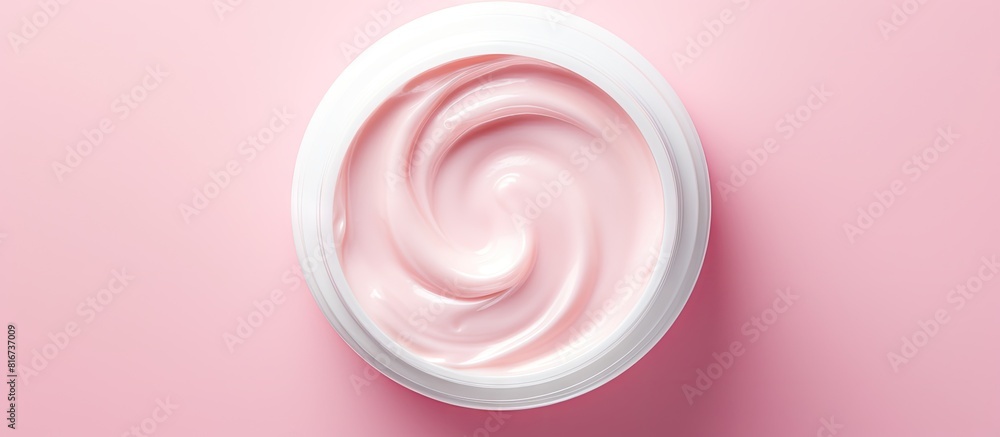Aufkleber Top view of a moisturizer with a half opened lid placed on a light pink background in a flat lay style with copy space image
