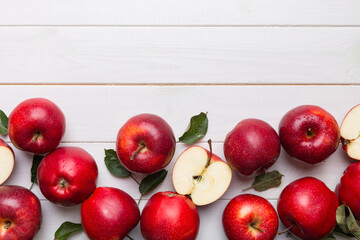 Fresh red apples with green leaves on wooden table. On wooden background. Top view free space for text
