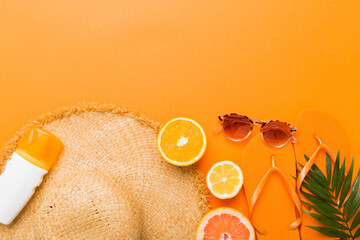 Top view of various seashells placed near colorful fruit and stylish summer accessories on table...