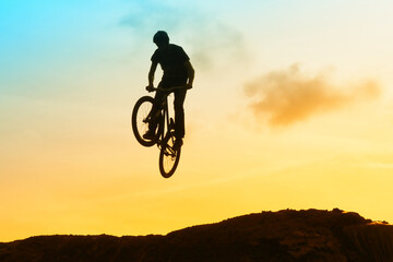 An extreme man jumping on the trial bicycle in the mountains.
