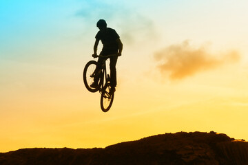 Obraz premium An extreme man jumping on the trial bicycle in the mountains.