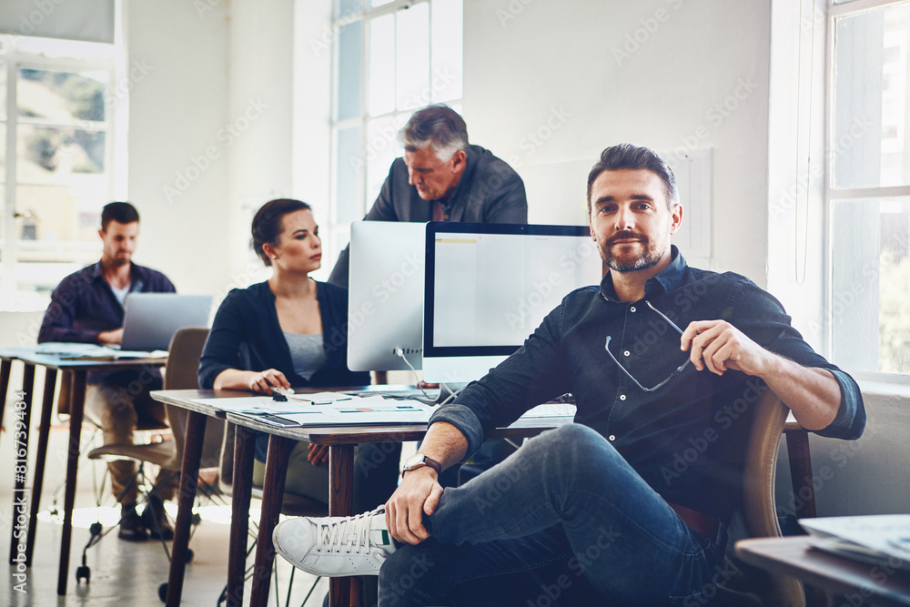 Poster man, portrait and relax in office with computer for research and product development for company wit