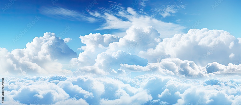 Poster The spacious blue sky is adorned with large billowing white clouds creating an ideal copy space for adding text