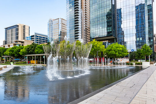 Modern commercial buildings and the Nancy Best Fountain in Dallas downtown. View from Klyde Warren Park in Texas, USA
