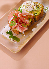 Gourmet avocado toast with prosciutto and poached egg