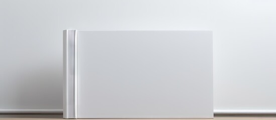 Copy space image of a blank white book resting on a white paper backdrop