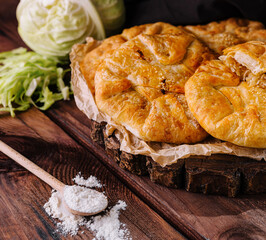 Rustic homemade cabbage pie on wooden table