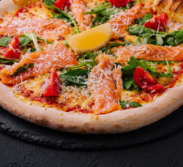 Gourmet smoked salmon pizza on dark background