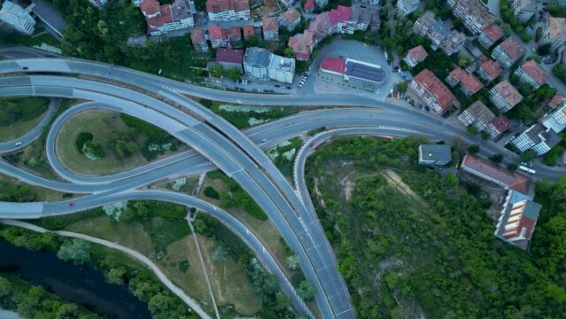 Aerial high angle top down shot of a complicated road network in Veliko Tarnovo. Bulgarian road system confusing and complex seen from above. Drone footage of traffic flowing on multy level roads.
