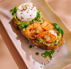 Gourmet avocado toast with shrimp and poached egg