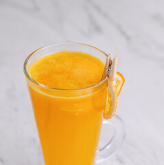 Fresh orange juice in glass on marble background