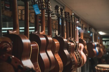 Image of a music store with multiple guitar instruments suspended from strings