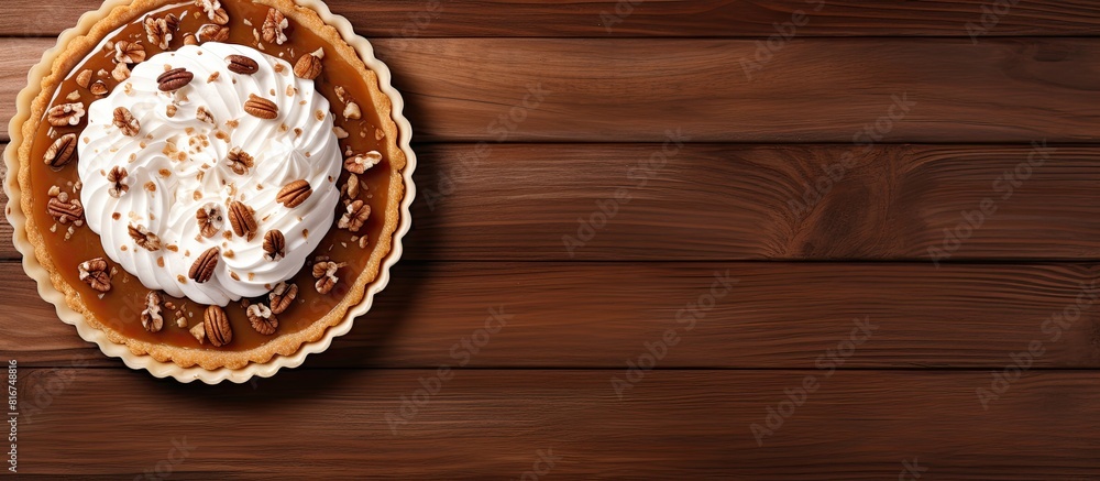 Poster top view of a delicious nut and caramel tart on a wooden background with ample copy space for additi