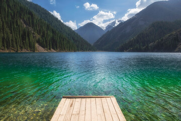 wooden pier on a mountain lake with turquoise clear water. Lake Kolsai or Kulsay in the mountain range of Kazakhstan