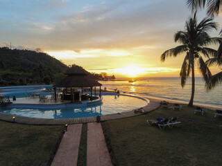 A pool at a resort  in Ilheu das Rolas, Sao tome  with sunset reflecting in the sea