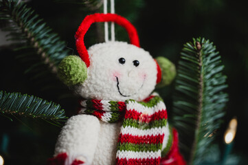 Closeup of a festive stuffed animal decoration, hanging from a Christmas tree