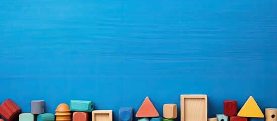 Frame made of wooden educational toys on a blue background with space for text. copy space available