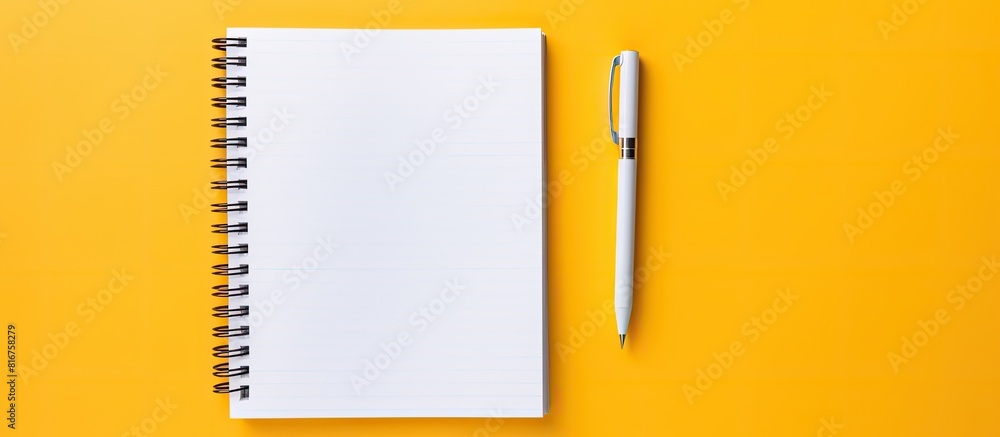 Poster notebook with a spiral and pen lie on a yellow background flat lay. copy space available