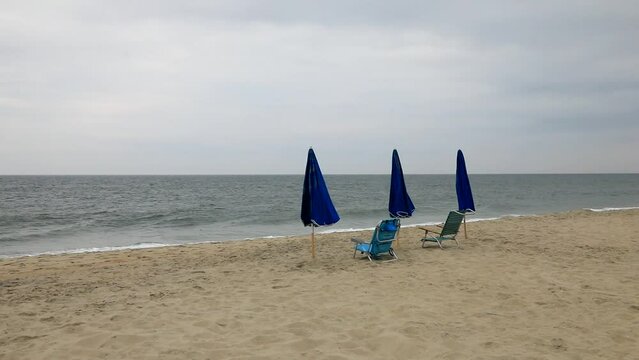 Beach umbrellas and chairs with overcast sky in the background at Bethany Beach, Delaware, USA