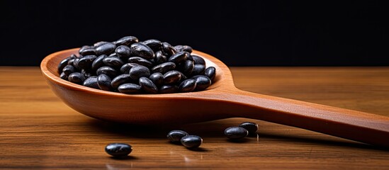 Black bean on a wooden spoon copy space