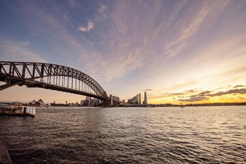 Bridge crossing a body of water at sunset in Sydney, Australia.